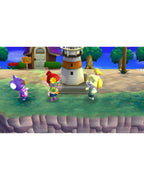 Drei Charaktere stehen in Animal Crossing: New Leaf - Welcome amiibo am Strand vor einem Leuchtturm.