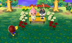 In Animal Crossing: New Leaf World Edition sitzen zwei Charaktere auf einer Bank, umgeben von Blumen.
