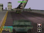 Ein grüner Panzer fährt auf einer Landebahn, im Hintergrund ist ein großes Flugzeugwrack zu sehen.