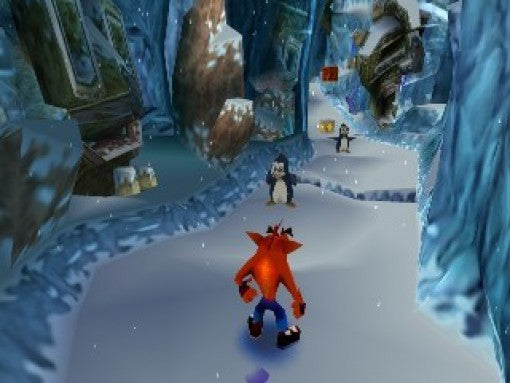 Crash Bandicoot läuft in einem Eis-Level auf zwei Pinguine zu.