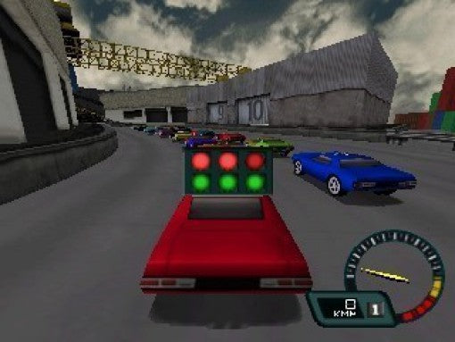 Ein rotes Auto steht an der Startlinie, die Ampel ist grün, weitere Rennwagen warten im Hintergrund.
