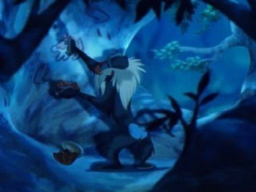 Der weise Pavian Rafiki steht in einer dunklen Höhle und hält eine Frucht in der Hand.