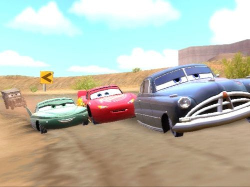 Drei Autos, darunter Lightning McQueen, fahren auf einer staubigen Rennstrecke.