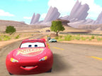Lightning McQueen fährt auf einer staubigen Wüstenstraße mit Felsformationen im Hintergrund.