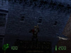 Duke Nukem steht auf einem Dach und blickt zu einem dunklen Gebäude mit Fenstern hinauf, rechts fliegt ein kleiner Hai.