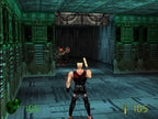 Duke Nukem steht in einem futuristischen, grün beleuchteten Korridor und zielt auf zwei Gegner mit roten Augen.