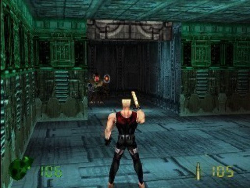 Duke Nukem steht in einem futuristischen, grün beleuchteten Korridor und zielt auf zwei Gegner mit roten Augen.