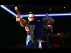 Duke Nukem hält eine Pistole und benutzt einen blau gepanzerten Alien-Gegner als menschliches Schutzschild.