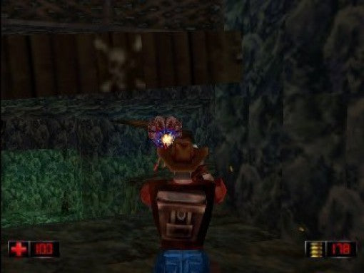 Duke Nukem im Cowboy-Outfit schießt in einer dunklen Höhle auf einen Gegner, der bläulich leuchtet.