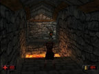 Duke Nukem steht in einem Steingang vor einem Gegner, im Hintergrund ist glühende Lava zu sehen.