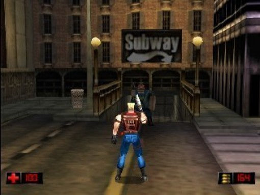 Duke Nukem steht vor einem Subway-Eingang und zielt auf einen Gegner auf einer Brücke.