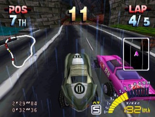 Zwei Rennwagen fahren in Explosive Racing auf der PS1 bei Regen auf einer Strecke, aus der Verfolgerperspektive.