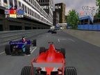 Ein roter Formel-1-Wagen fährt auf einem Stadtkurs, verfolgt von weiteren Rennwagen und Gebäuden.