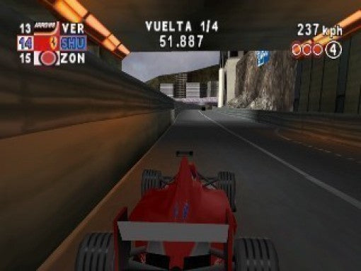 Ein roter Formel-1-Wagen fährt durch einen Tunnel auf einer Rennstrecke, mit Felsen am Ausgang.