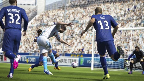Eine Szene aus Fifa 14 zeigt einen Spieler in blauem Trikot beim Schuss auf das Tor, umgeben von anderen Spielern.