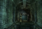Lara Croft schwingt sich an einem Seil durch eine dunkle, steinerne Höhle.