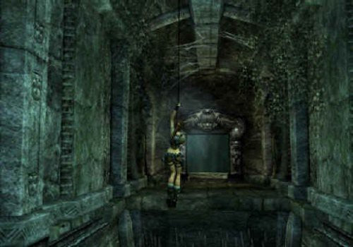 Lara Croft schwingt sich an einem Seil durch eine dunkle, steinerne Höhle.