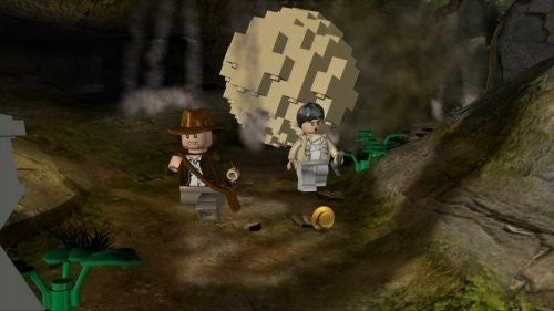 LEGO Indiana Jones und eine weitere Figur fliehen in einer Höhle vor einem riesigen rollenden Stein.