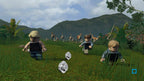 Drei Lego-Figuren rennen in LEGO Jurassic World vor einer Gruppe Raptoren über eine Wiese.