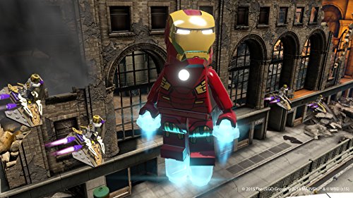 Iron Man schwebt in Lego Marvel Avengers vor einem zerstörten Gebäude und kämpft gegen Drohnen.