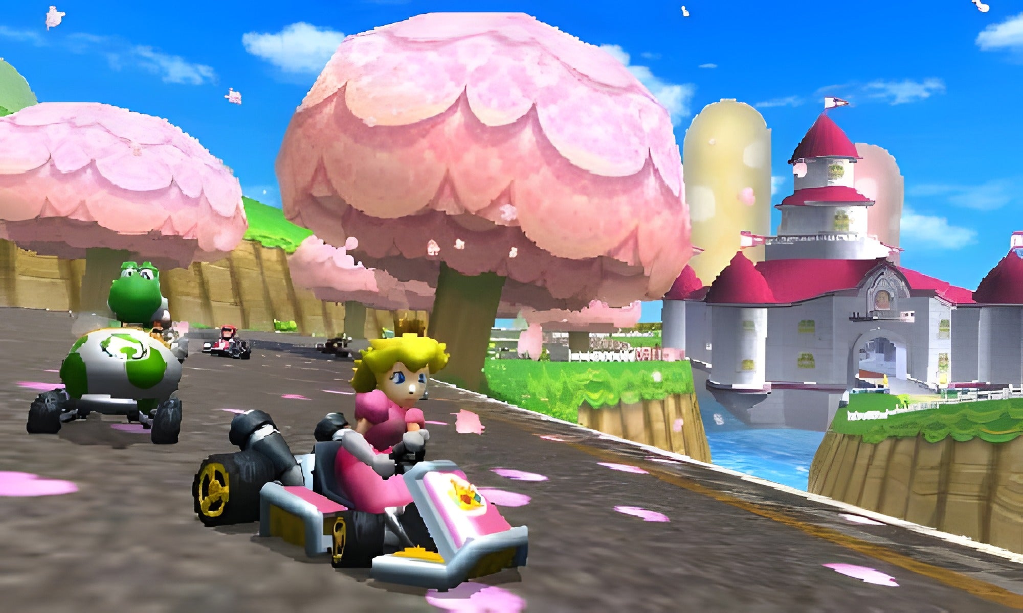 Prinzessin Peach fährt in Mario Kart 7 für Nintendo 3DS vor einem Schloss mit Kirschblütenbäumen.