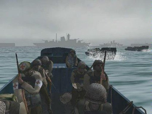 Soldaten sitzen in einem Landungsboot auf dem Meer, im Hintergrund sind weitere Schiffe zu sehen.