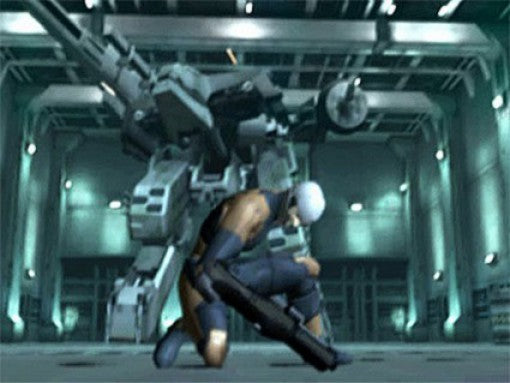 Solid Snake hockt in einer Halle vor dem riesigen bipedalen Roboter Metal Gear REX.