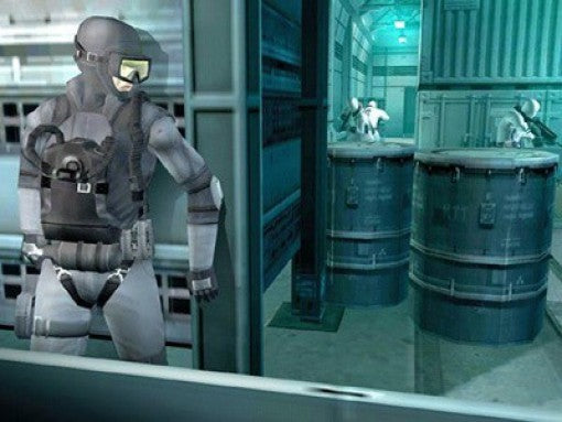 Solid Snake in Tarnkleidung späht in einem metallischen Gang um eine Ecke, während zwei Gegner hinter Fässern lauern.