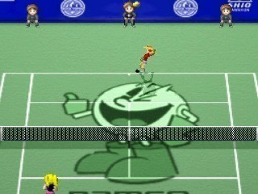 Ein Tennisspieler im roten Trikot schlägt den Ball auf einem grünen Platz mit Pac-Man-Logo.