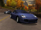 Ein blaues Sportauto fährt auf einer Straße durch eine herbstliche Landschaft.