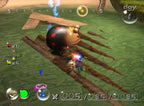 Pikmin greifen einen großen, marienkäferähnlichen Gegner auf Holzplanken über Wasser.