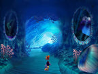 Rayman M für PS2 zeigt Rayman in einer Unterwasserhöhle mit Korallen und zwei Fischen in ovalen Spiegeln.