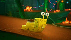 Gary die Schnecke im Lego-Kostüm kriecht über einen braunen Untergrund in einer dunklen Umgebung.