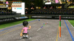 Ein männlicher Avatar in einem pinken T-Shirt spielt auf einem Sportplatz eine Art Bowling mit Kugeln und Pins.