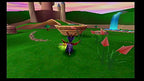 Der lila Drache Spyro steht auf einer grünen Wiese vor einem Schloss und einem Wasserfall.