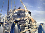 Mehrere Pinguine stehen vor einem Schiff, das aus großen Knochen gebaut ist, mit einer Person obenauf.