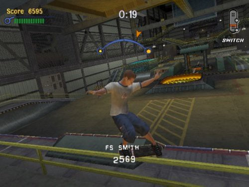 Ein Skater führt einen Grind auf einem gelben Geländer in einer Fabrikhalle aus, mit Score-Anzeige.