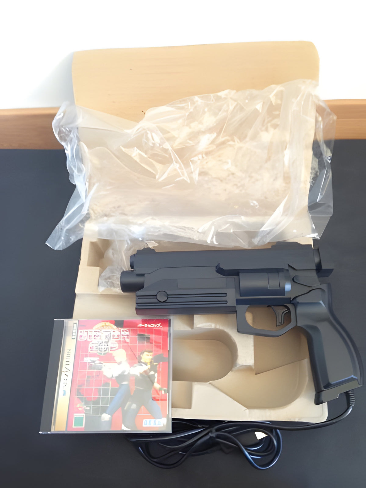 Der Inhalt von Virtua Gun Set: Virtua Cop + Virtua Gun zeigt die Lightgun und das Spiel in der Box.